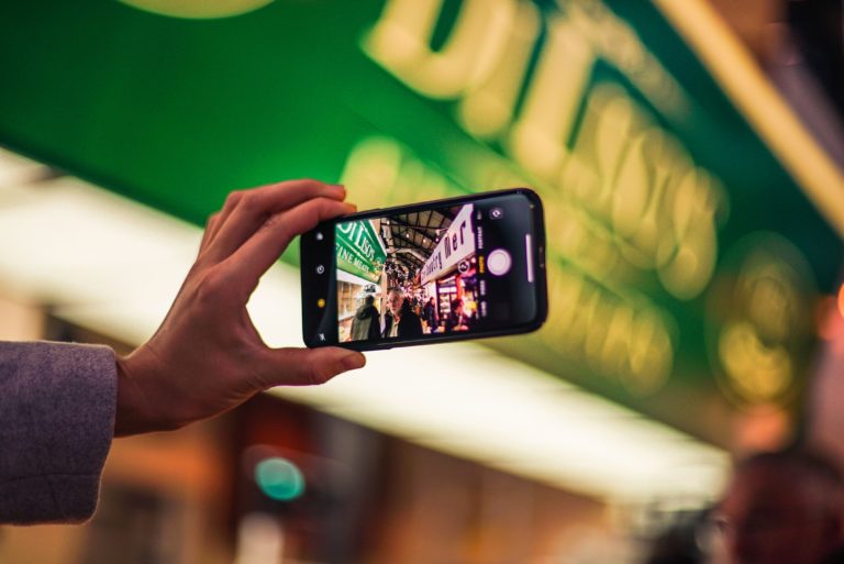 Eine Person hält ein Handy mit geöffneter Kamerafunktion